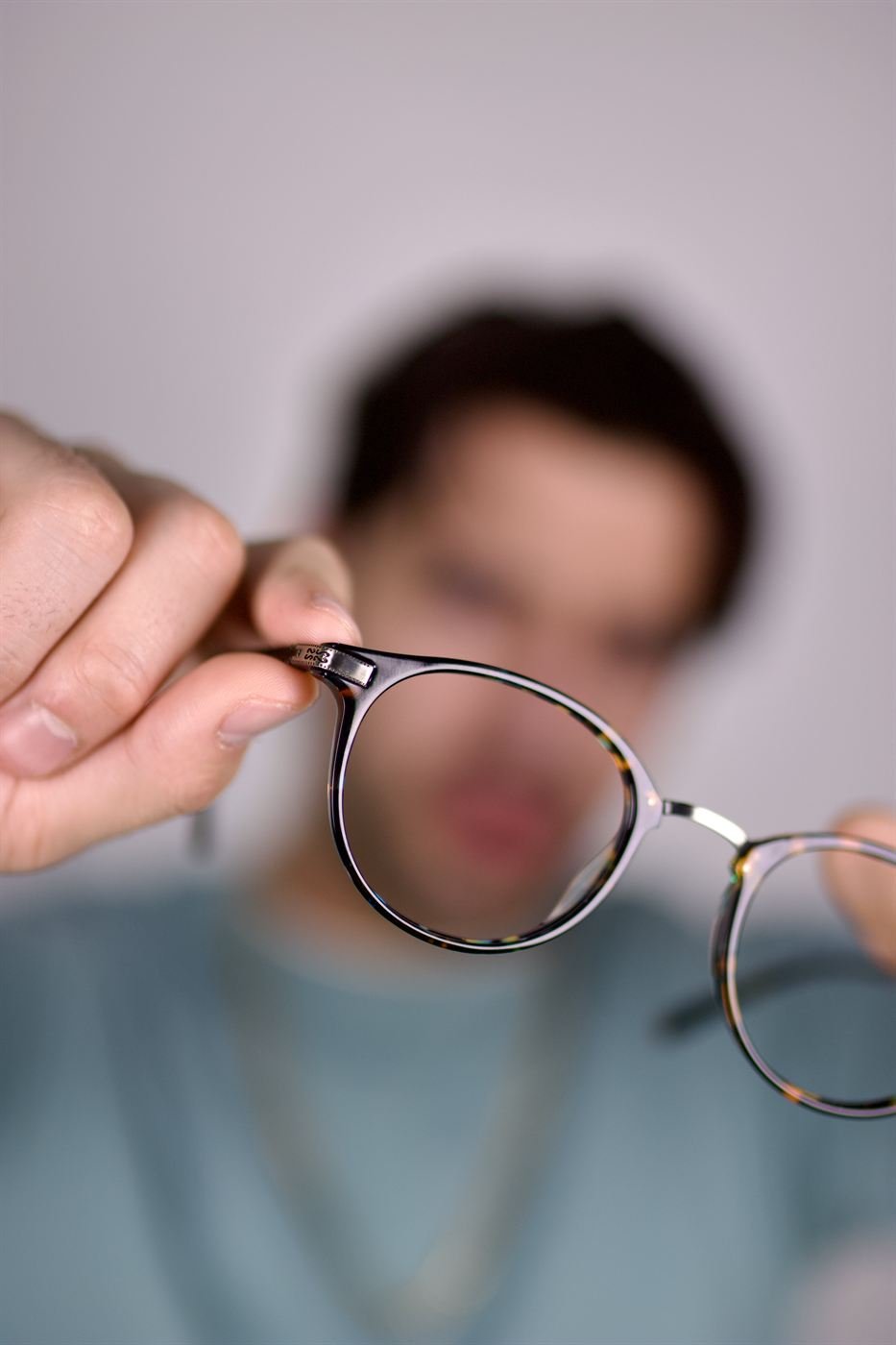Mano sosteniendo unos lentes frente a la cámara